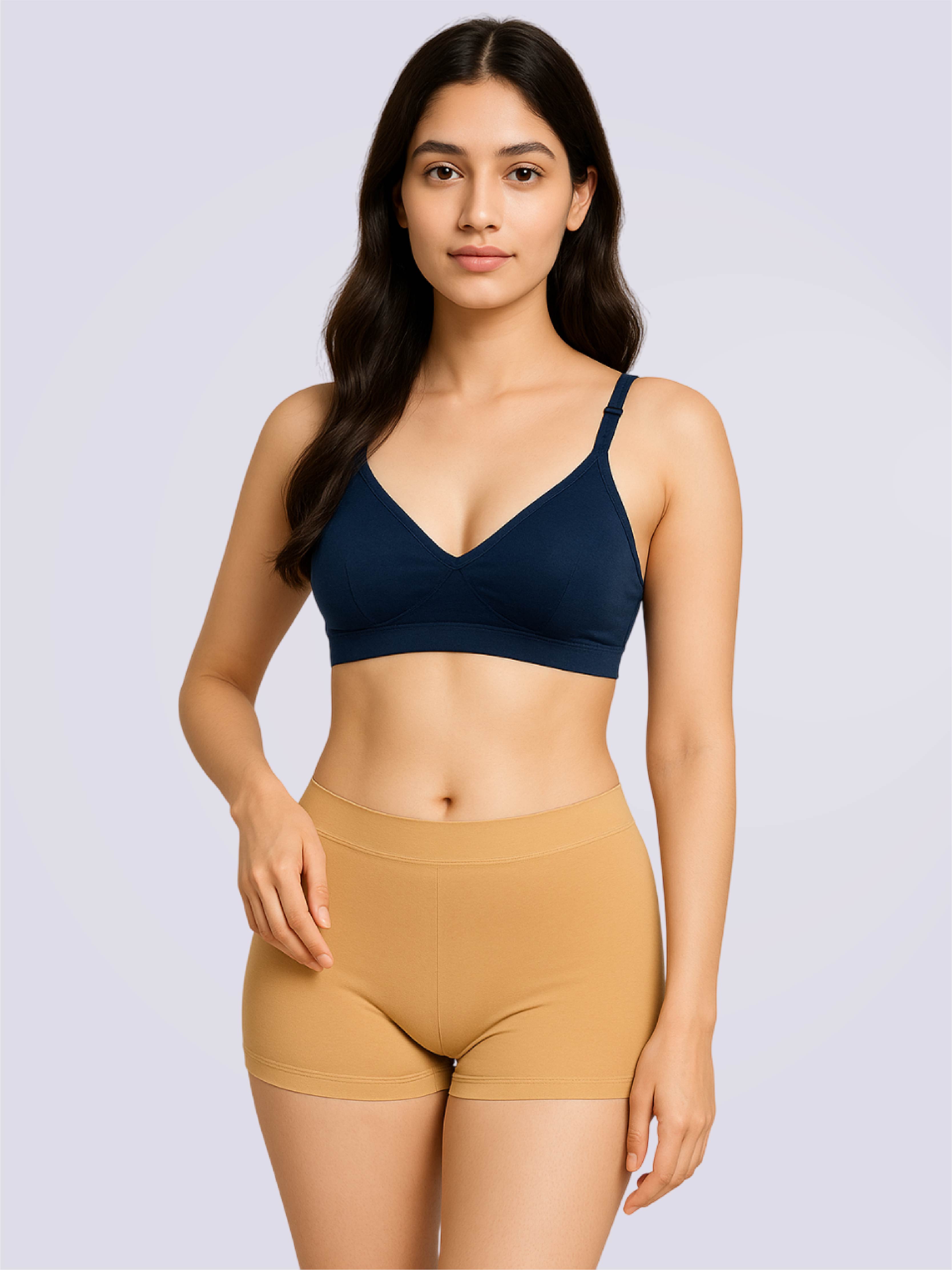 Woman wearing a navy blue bra and beige shorts on a light gray background